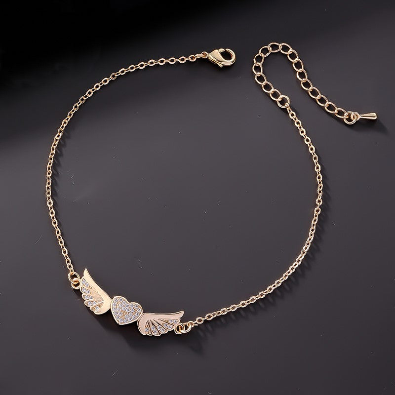 Tobillera Corazón Alas de Ángel con Circones Blancos. Acero Titanio Chapado Oro 18K